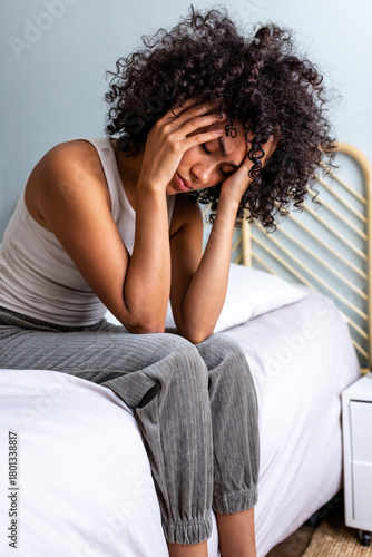 Fototapeta Woman experiencing headache and stress feeling pain in bedroom