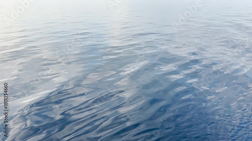 Tranquil Serenity: Calm Waters Reflecting Sunlight on a Peaceful Ocean Horizon. HDR Video, Seamless Loop