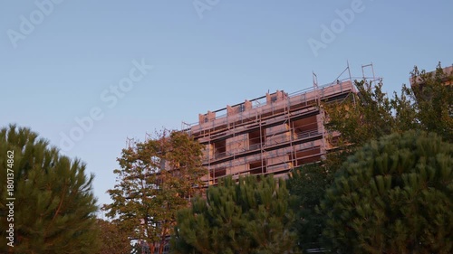 Construction Site with Two Adjacent Apartment Buildings Behind Green Trees
