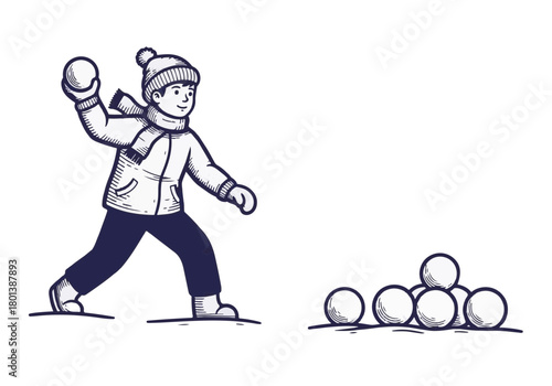 Young child wearing winter clothing is playfully preparing to throw a snowball while standing beside a pile of snowballs, capturing the joy of winter playtime