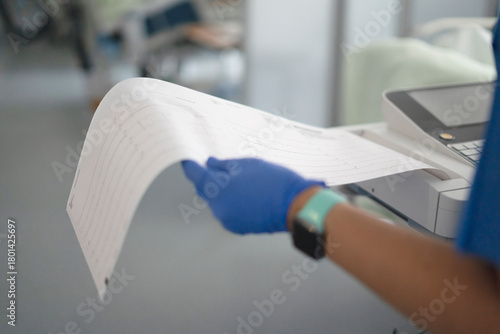 Healthcare professional holding ekg paper with heart data