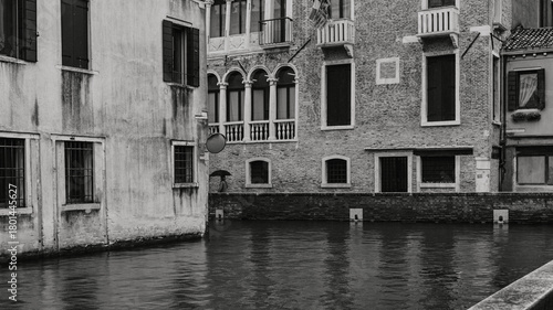 A person holding an unmbrella in an alleway in Venice