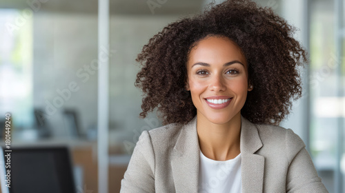 Smiling professional woman with curly hair office setting conveying friendly confident demeanor