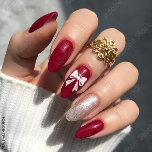 Elegant red almond nails with bow accent and glitter