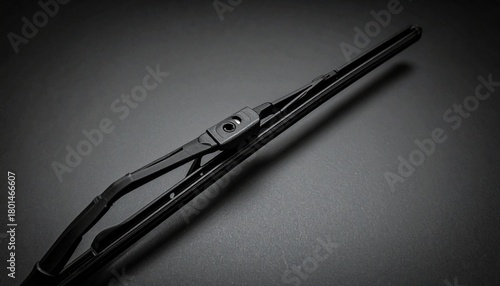 Wallpaper Mural A close-up view of a windshield wiper blade with visible mounting mechanism, rubber strip, and frame. Set against a dark background with soft lighting to highlight its structure and automotive functio Torontodigital.ca