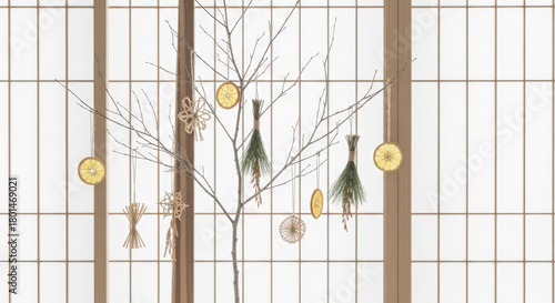 Minimalist winter decoration with dried citrus and pine sprigs hanging on bare branches against a shoji screen background.