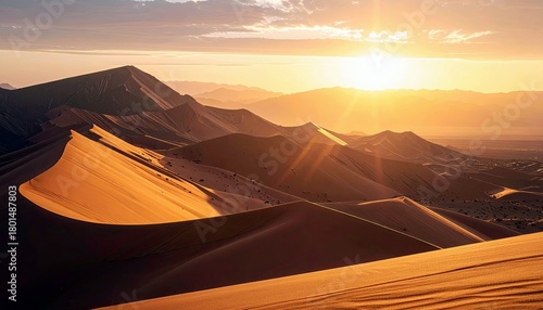 Fototapeta Naklejka Na Ścianę i Meble -  Vast desert landscape with rolling sand dunes bathed in the warm glow of a setting sun, casting long shadows and creating dramatic light.