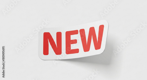 A white sticker with the word new in red letters, slightly peeled off a, casting a soft shadow, isolated on