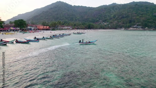 beach.dynamic shot,drone tracking a boat with people in the sea, going into open sea