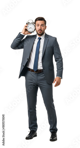 A man, looking stressed, holding a ticking alarm clock next to his ear