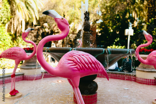 Sculpted pink flamingos around a scenic fountain