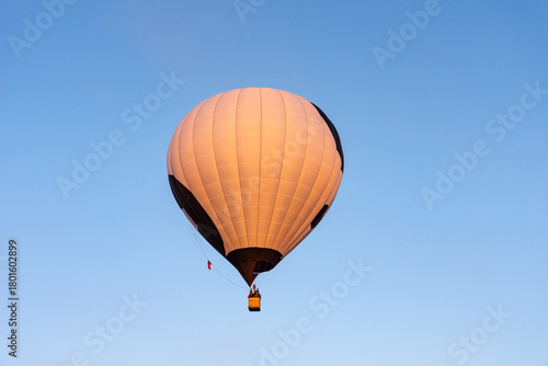 White with black hot air balloon in the sky. Beautiful balloon against a blue sky.