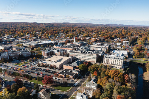 Aerial view of buildings nestled amidst a tapestry of autumn colors, where the architecture contrasts with the natural landscape, West Hartford, Connecticut, United States.