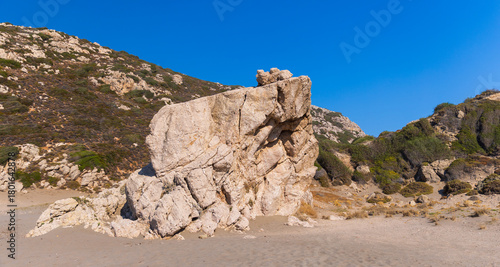 Fototapeta Naklejka Na Ścianę i Meble -  Coastal scene showcasing a prominent rock formation surrounded by natural terrain