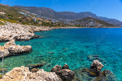 Fototapeta Naklejka Na Ścianę i Meble -  Wild beach Kalkan landscape photo. Turquoise waters lap a rugged rocky coast