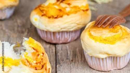 Golden baked buns with toppings on wooden surface