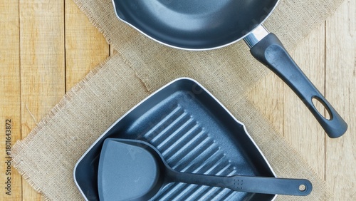 Kitchen cooking utensils and pans on a wooden background