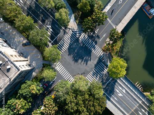 Aerial view of a crosswalk intersection with trees and a river