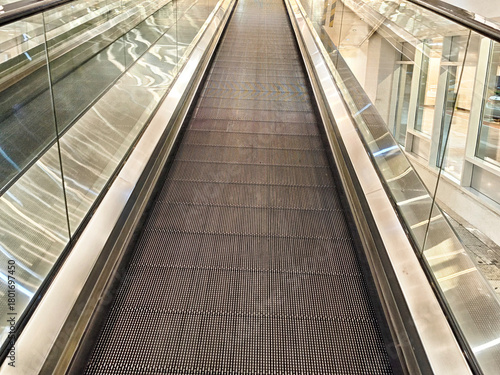 Moving walkway in a modern shopping center with glass walls and sleek design