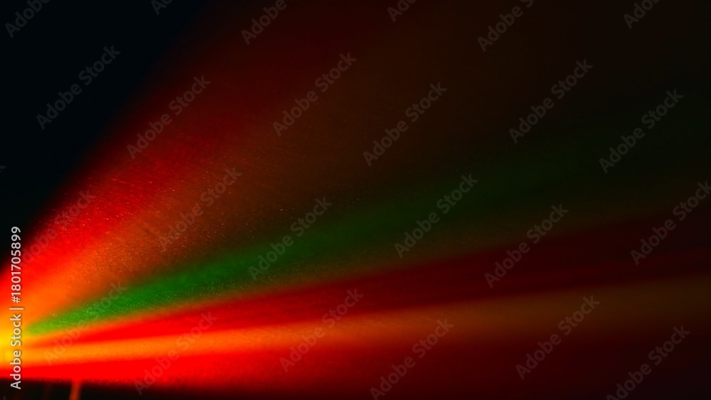 Fototapeta premium Vibrant Red Green and Yellow Light Beams on Dark Background