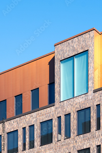 A sharply defined facade in stockholm reveals architecture shaped by geometry, contrast and color, enriched with minimalism, illuminated with hard light and unified by urban pattern and modern design