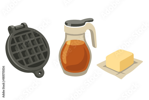 Waffle iron, maple syrup dispenser, and stick of butter for breakfast preparation