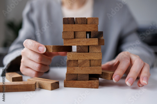 Fotografie Abstract business woman fail danger tower block game building construction protect plan and project control