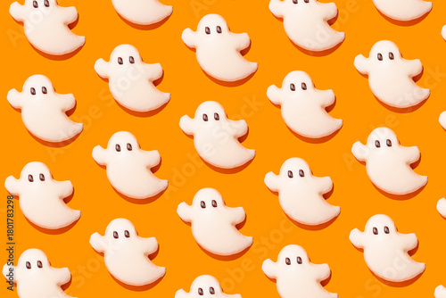 Ghost-shaped Halloween cookies on orange background
