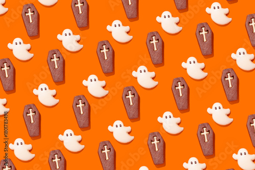 Halloween themed ghost and coffin cookies on orange