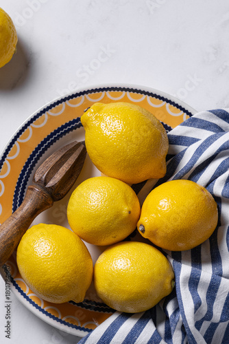 Lemons on decorative plate with wooden reamer