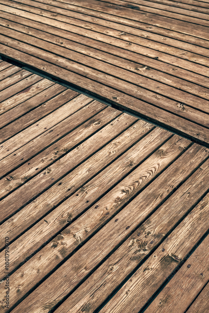 Fototapeta premium Closeup texture of wooden pier boards with natural grain and weathered surface pattern.
