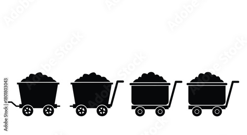 Four coal carts filled with coal in silhouette