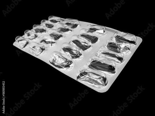 Used medication packaging on black