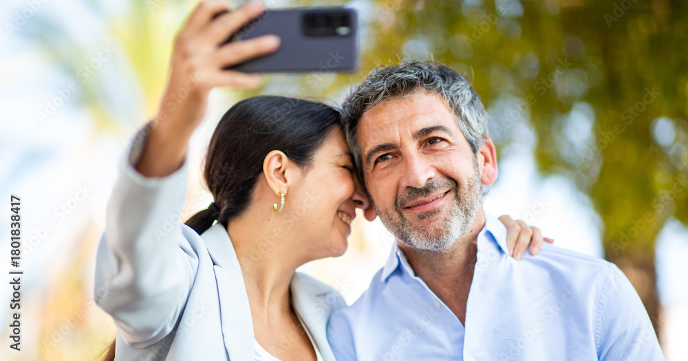 Obraz premium Close-up of a loving couple taking a selfie outdoors with joyful expressions