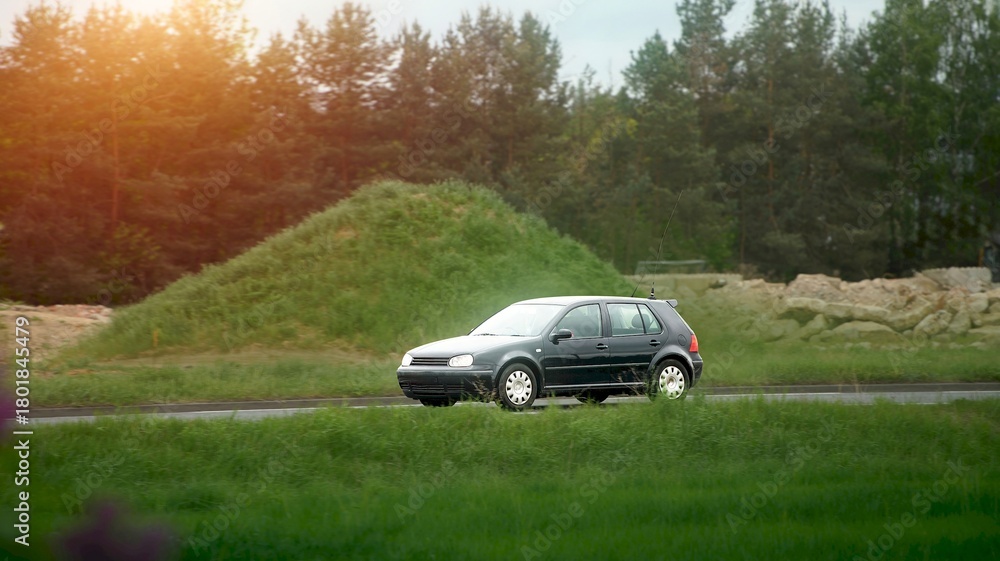 Fototapeta premium White urban vehicle driving near field