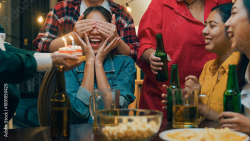 Group of young adult Asia friend surprised with birthday cake and drinking alcohol beer and fun laugh enjoy hangout party in night life indoor home. Happy hour time millennial generation inside house.
