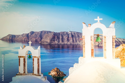 Fototapeta Naklejka Na Ścianę i Meble -  two white church belfries and volcano caldera with sea landscape, beautiful details of Santorini island, Greece