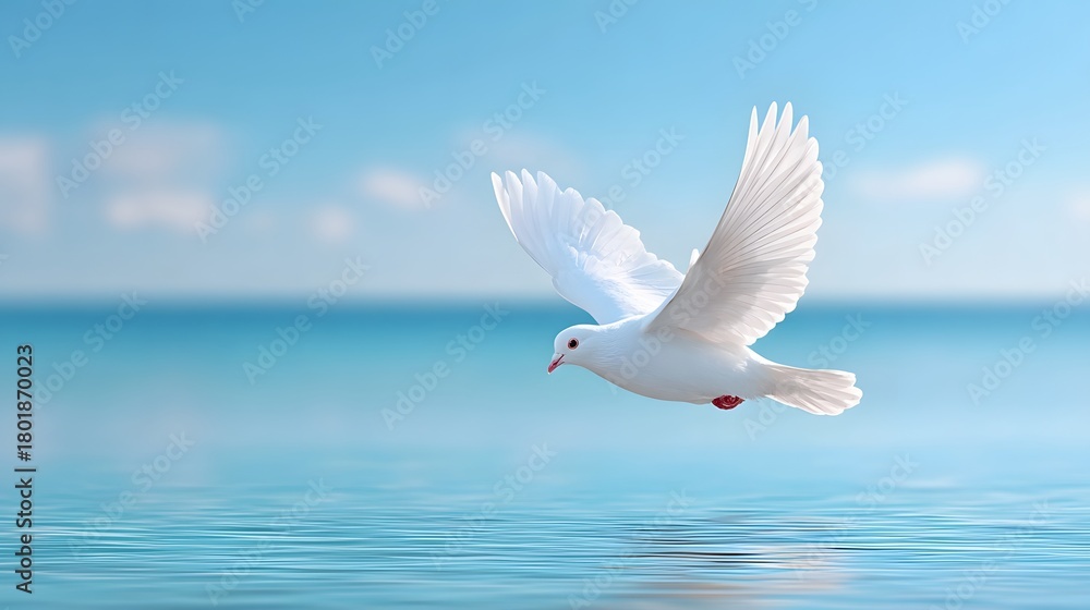 Fototapeta premium Symbol of peace and freedom a pristine white dove with wings spread wide flies low over the gentle waves of a serene turquoise sea and bright blue sky