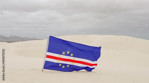 The Cape Verde flag flies in the Viana Desert, overcast day, Boa Vista island, Cape Verde.