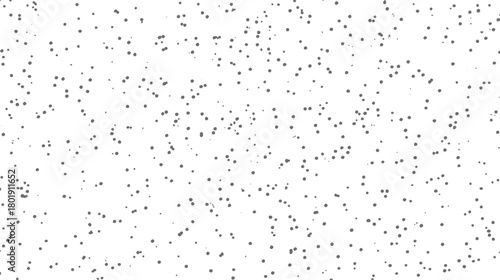 Scattered small dark grey dots of varying sizes on a plain white background creating a speckled pattern