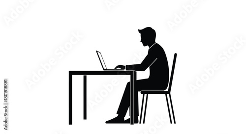 Silhouette of a man sitting at a desk and typing on a laptop computer in a studio setting