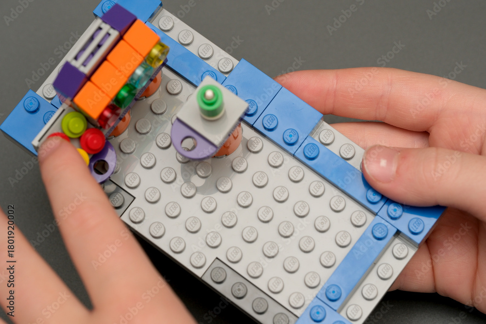 Naklejka premium Building a colorful LEGO creation on a gray surface