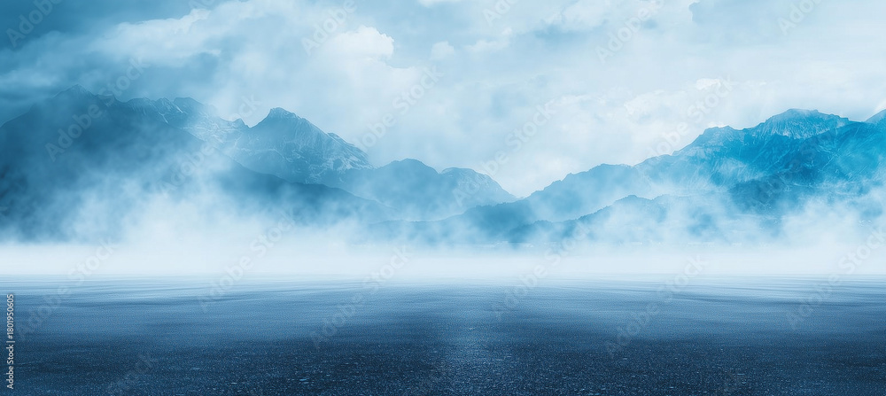 Fototapeta premium Mystical foggy alpine mountains rising above calm reflective lake at dawn