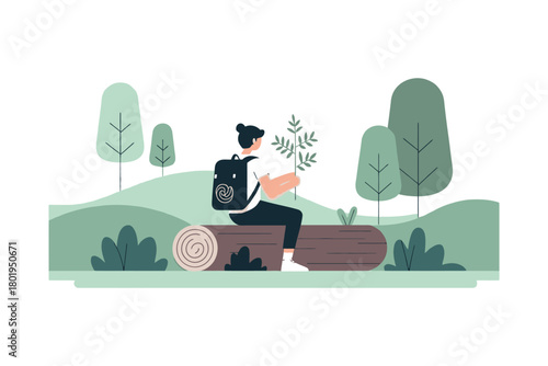 A person sits on a log in a forest holding a plant.