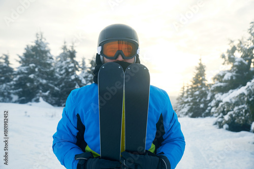 Fényképezés Skiing enthusiast preparing for a winter adventure in a snowy landscape during early morning hours