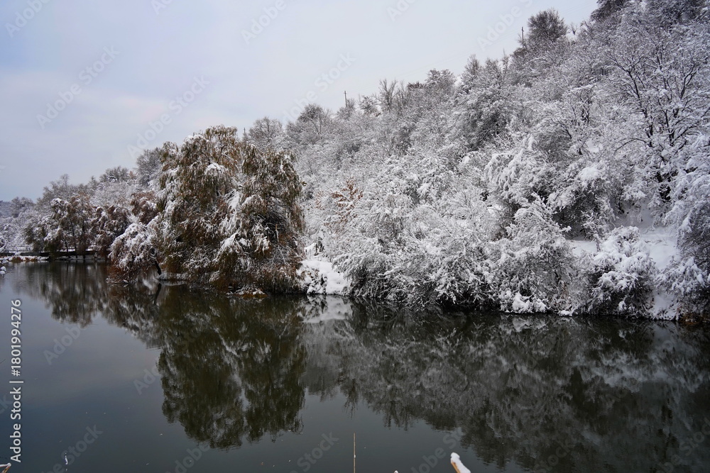 Fototapeta premium Soldier Lake after the first snow. A lake in a mountainous area with a variety of vegetation. November.