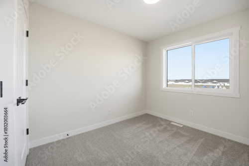 Very clean and empty bedroom with a large window