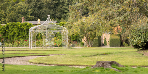 White Garden Gazebo in Lush Park Setting, Tranquil Outdoor Scene with Greenery and Pathway