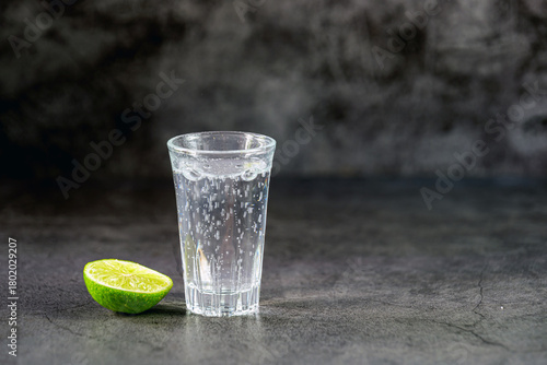 Vodka. Shots, glasses with vodka soda with ice and lime on gray background