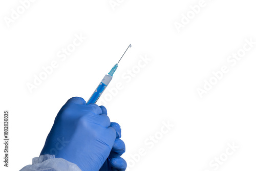 Hand holding a syringe with blue liquid ready for vaccination or medical procedure